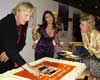 Rutger Hauer with Consul Nora Stehouwer (right) cutting the party cake offered by the Consulate General of the Kingdom of the Netherlands